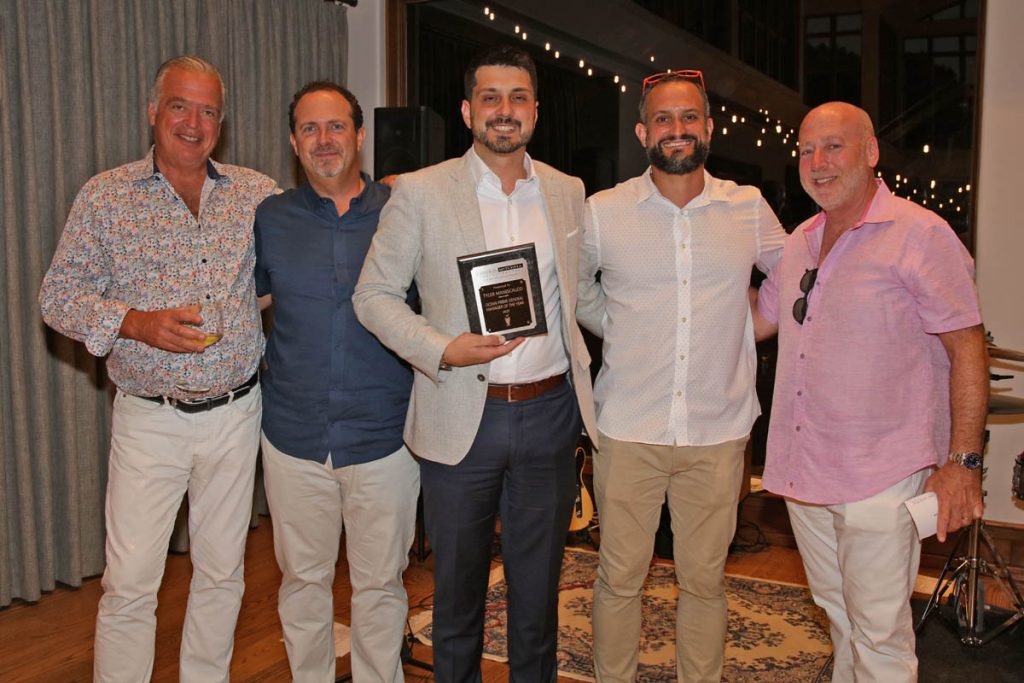 Group of people standing with award winner.