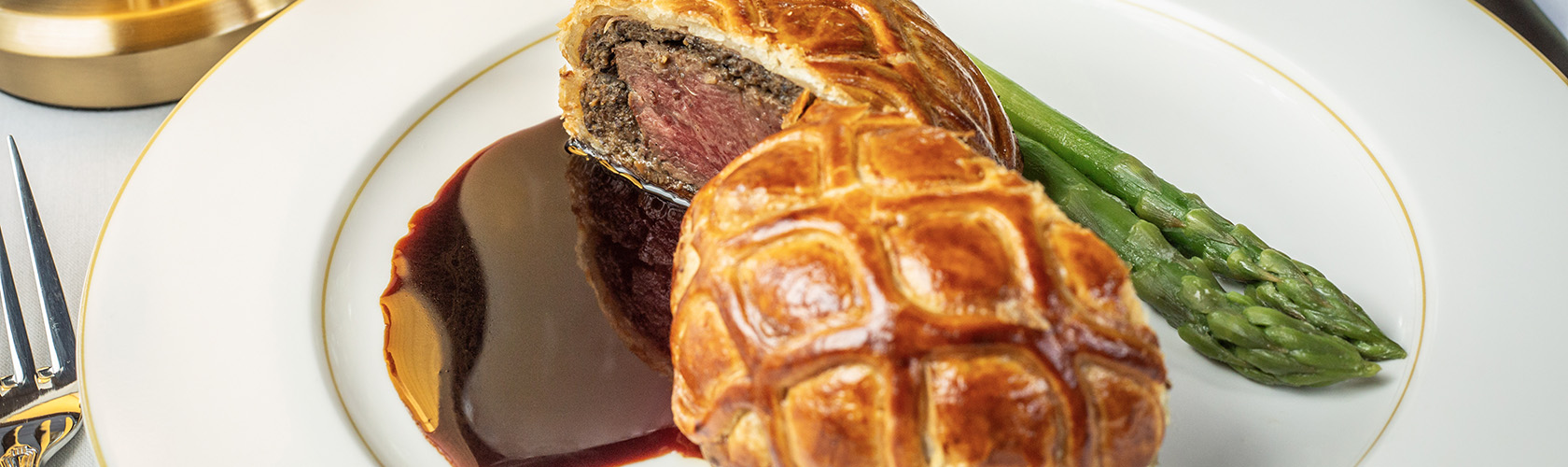 Beef Wellington plated with asparagus, served at Butcher & Rose, a Cameron Mitchell Restaurant.