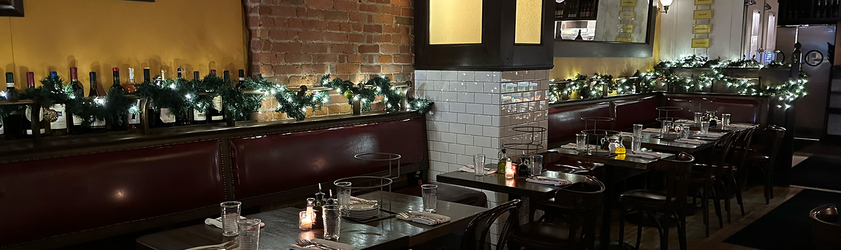 Tables lit with candles and holiday lighting at a Cameron Mitchell Restaurant